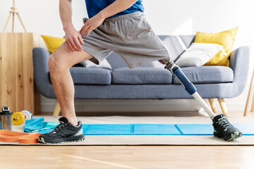 Man with amputated leg stretching in living room