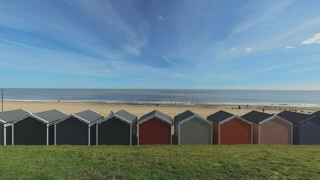 View over the wooden huts, seaside promenade and sandy beach from above. Captured on Gorleston beach on the Norfolk coast on a bright and sunny day