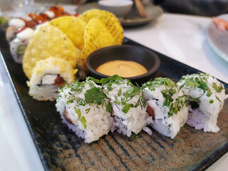 Fotografia de un plato negro con vairas piezas de Sushi
