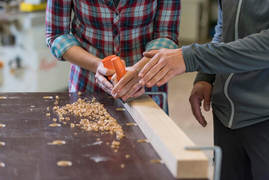 Craftsman assisting trainee in workshop