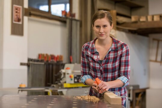Young craftswoman working in woodshop