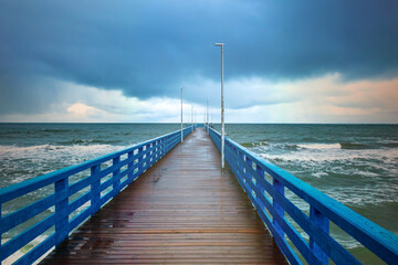 Obraz premium wooden promenade, pedestrian boardwalk embankment, walking bridge over the sea