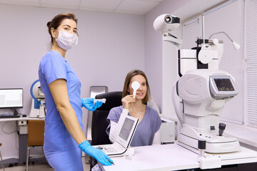 Ophthalmologist performing vision diagnosis test on patient at clinic