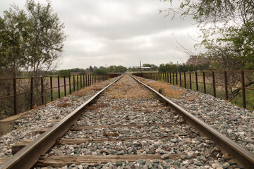 Detail of the rails of the tracks of a train that are lost in the infinity surrounded by boulders. Concept trains, tracks, transport, roads.