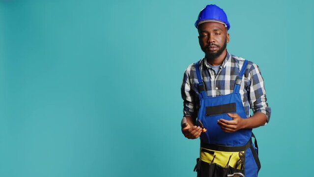 Dizzy construction worker feeling light headed in studio, almost fainting and having cartoonish stars above his head. Male contractor with hardhat being disoriented and unsteady, looney tunes.