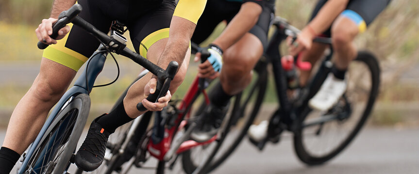Cycling competition, cyclist athletes riding a race at high speed. Leaning into a corner. Focused on cycling shoes