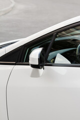 Fototapeta na wymiar Side rear-view mirror on a white car