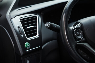 Obraz na płótnie Canvas Economic green mode button in a modern car and part of a steering wheel and air conditioning system