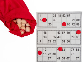 Board game bingo. Wooden barrels with lotto numbers, playing cards for the game. Close-up.