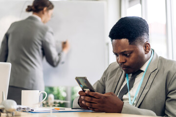 Portrait of african businessman relaxing using digital smartphone.Young african businessman looking at screen typing message work and playing game online or social media at office