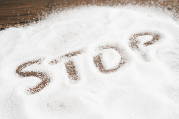 STOP, sweet granulated sugar with text, diabetes prevention, diet and weight loss for good health.