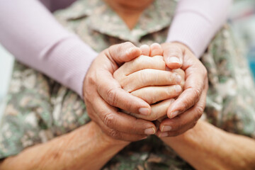 Caregiver holding hands Asian elderly woman patient, help and care in hospital.