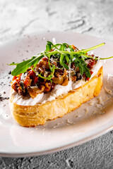 Bruschetta with tapenade, cream cheese and arugula on plate