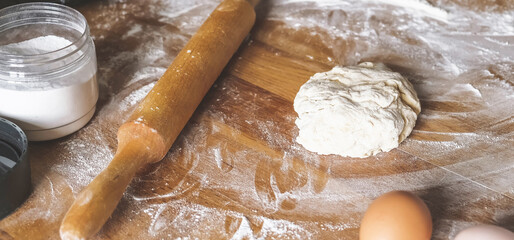 Girl prepares dough for bread.Homemade baking.Dough and hands close-up,ingredients for dough