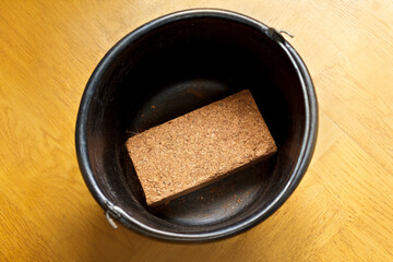 How to make cheap and eco-friendly grow or potting soil from coconut bricks, step 1: place the dry block of compressed coco coir in a suitable bucket.