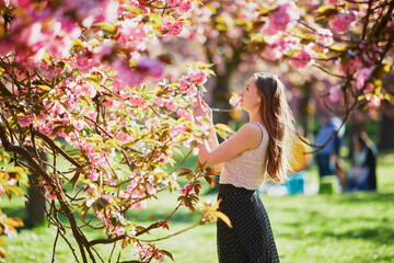 Beautiful girl in cherry blossom garden on a spring day