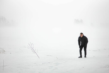 man in a warm jacket in a snowfall in a snow field.