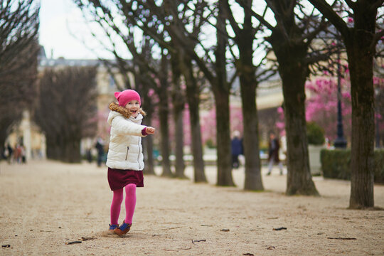 Cheerful preschooler girl having fun on a street of Paris, France