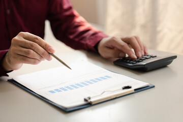 A financier is reviewing company financial documents, monthly financial statement summary from the finance department. The concept of managing the company's finances for accuracy and growth.