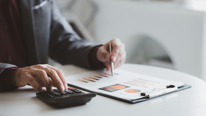 A financier is reviewing company financial documents, monthly financial statement summary from the finance department. The concept of managing the company's finances for accuracy and growth.