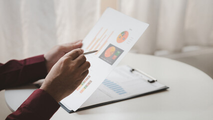 A financier is reviewing company financial documents, monthly financial statement summary from the finance department. The concept of managing the company's finances for accuracy and growth.