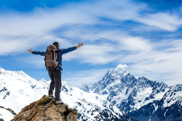 Hiker on the mountain top with his hands outstretched. Sport and active life concept