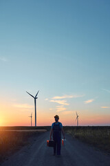 Fototapeta premium Engineer mechanic in a windmill farm park checking and servicing wind turbines.