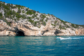 Mare blu e le caratteristiche grotte naturali di Cala Luna, Dorgali, Golfo di Orosei, Sardegna, Italia. Grandi grotte marine nella costa mediterranea. Sardegna, Italia.