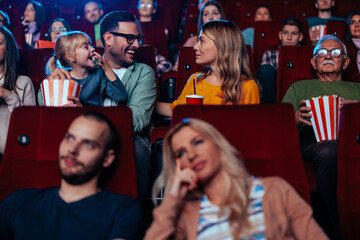Young parents with child in cinema.