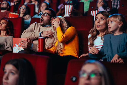 Scared couple in movie theater.