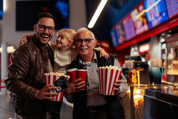 Excited multigenerational family in movie theater.