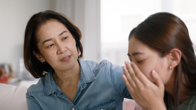 Middle aged asia people old mom love care trust comfort help young teen talk crying stress relief at home. Mum as friend listen adult child woman feel pain sad worry of broken heart life crisis issues