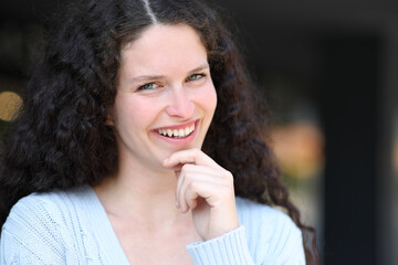 Happy woman smiling with curly hair in the street