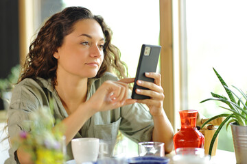 Woman checking smart phone in a restaurant