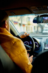Concentrated bearded man in casual clothes driving modern car