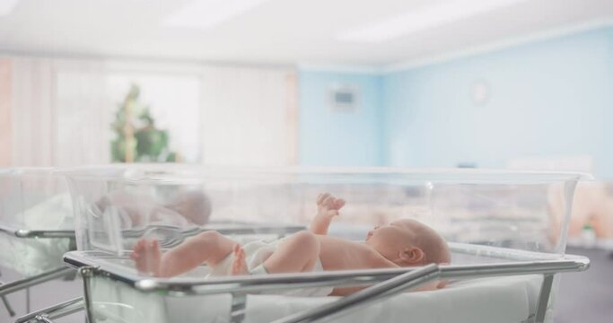 Portrait of a Young Newborn Baby Lying in a Bassinet in a Modern Maternity Ward After Birth. African American Nurse Walking By with Tablet Computer. Childbirth and Medical Clinic Concept