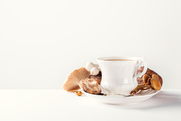 White porcelain vintage cup with mushroom coffee on white background. New Superfood Trend, selective focus and copy space