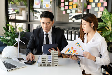Fototapeta premium Buying a home or insurance deal, an insurance agent pointing a pen to those interested in renting a house, a contract, signing an Home buying agreement in office.