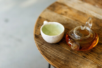 Warm cup of tea with teapot on the wooden desk at morning with banner background empty space for text,Organic product from the nature for health
