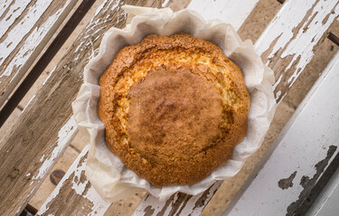 Top view of a freshly baked cupcake on aged wooden planks.