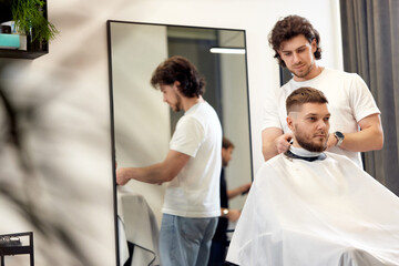 Fototapeta premium man visiting professional hairstylist in barber shop