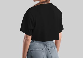 Black crop top mockup on a girl in gray jeans, back view, fashion women's canvas bella shirt close-up, isolated on background.