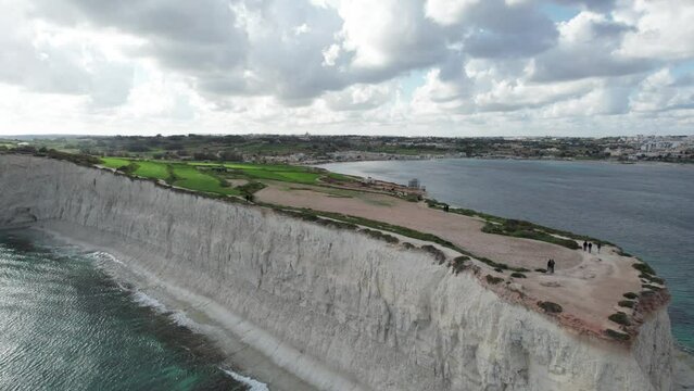 Bird's-eye view Over Ras il- Fenek Limestone Cliff Side, With Tropical Turquoise Water, Blue Sky And Fluffy White Clouds, Malta