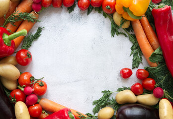 Fresh vegetables arranged in a circle on a light textured background copy space