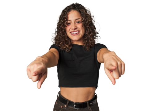 Radiant young woman with stunning curls cheerful smiles pointing to front.