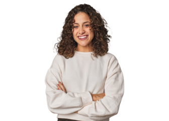 Radiant young woman with stunning curls who feels confident, crossing arms with determination.