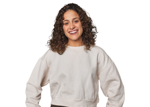 Radiant young woman with stunning curls confident keeping hands on hips.