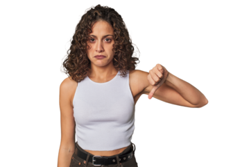 Radiant young woman with stunning curls showing a dislike gesture, thumbs down. Disagreement concept.