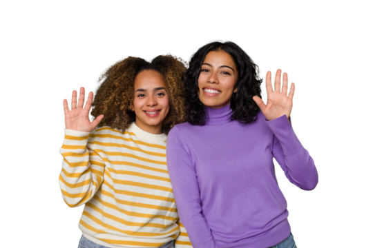 Two female friends isolated in studio smiling cheerful showing number five with fingers.