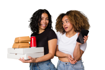 Two young women, one Latina and one with Afro hair, laugh as they hold pizzas and burgers from a recent delivery. 